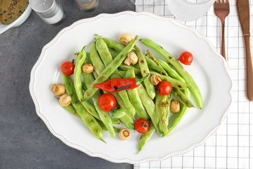 Plate with delicious green beans, mushrooms and cherry tomatoes on table