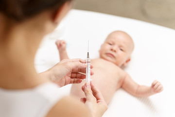 a nurse injects a newborn to prevent illness