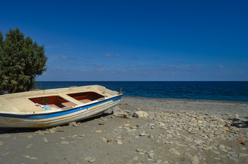 Fototapeta na wymiar View of the pebble beach of Maleme with a boat