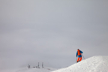 Skier before downhill on freeride slope and misty sky