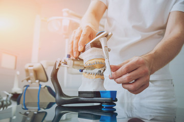 Dental technician working with articulator in dental lab
