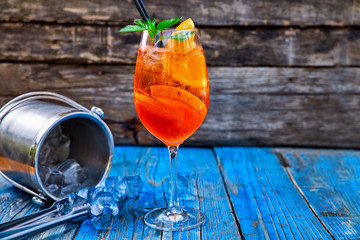 Spritz Aperol cocktail in wine glass on rustic wooden background