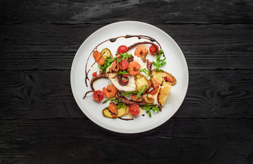 The seafood fried with ricotta on a white plate. Decorated with goji and ruccola.