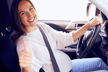 Pregnant woman showing thumb up for safety on road