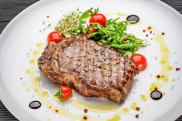 Marble stake with spicy herbs and sea salt over dark wooden background