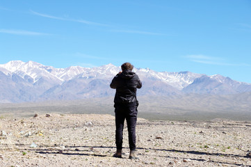 Homme devant la cordillère des Andes
