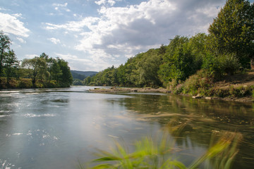 Fototapeta na wymiar Fluss mit Spiegelung Bäumen und Wolken im Bayerischen Wald