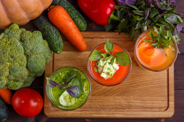 Diet concept, healthy lifestyle, low calorie detox and dietary food. Set of blended vegetable smoothies in glasses with ingredients on kitchen table