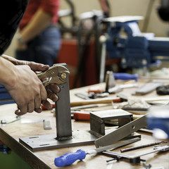 Handwerker in Werkstatt mit Zange, Metallbearbeitung, Nahaufnahme
