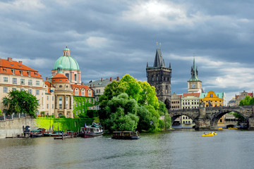 Fototapeta premium Landscape of the romantic city of Prague under a blue sky. Panoramic view of Charles bridge and old town on a summer day in the capital Czech Republic. Cruise on the Moldovan river.