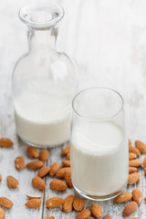 Obraz na płótnie Canvas Drinking glass and bottle of Almond milk