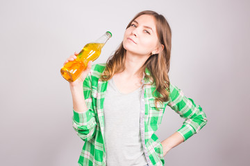 Young woman holding bottle of beer on white background