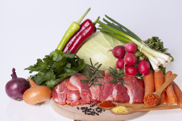 Fresh pork meat with vegetables on wooden board