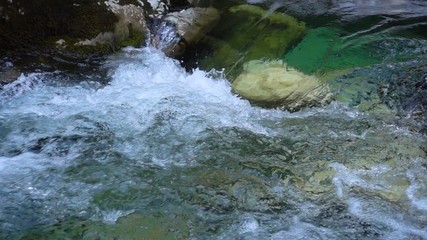 SLOW MOTION: flowing water over stones in mountines river