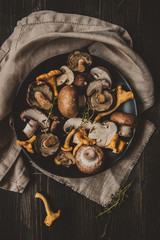 Fresh mixed forest mushrooms on the wooden black table