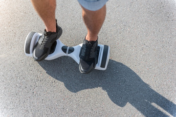 Male feet going on hoverboard at street