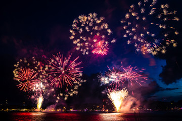 Fireworks over the water with port in the background 