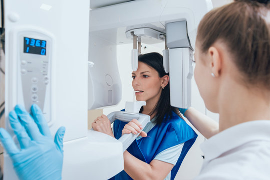 Young woman patient standing in x-ray machine.