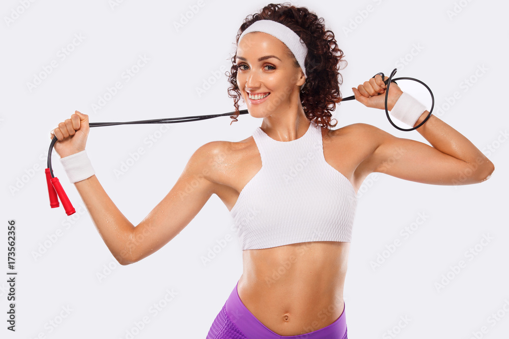 Wall mural Fitness and sporty beautiful woman exercising at white background to stay fit