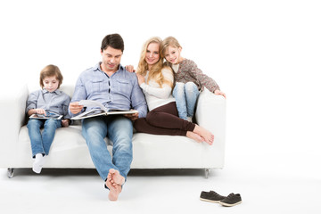 Happy family on sofa isolated on white.