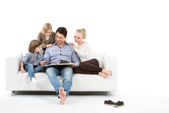 Happy Family On The Couch Read The Book Together Isolated.