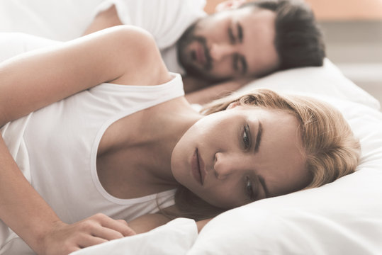 Anxious girl cannot sleep near her husband in bedroom