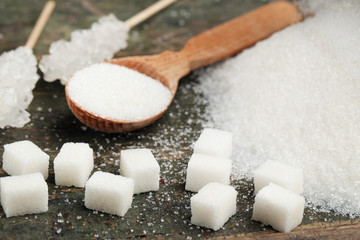 Sugar cubes with spoon on grey wooden table