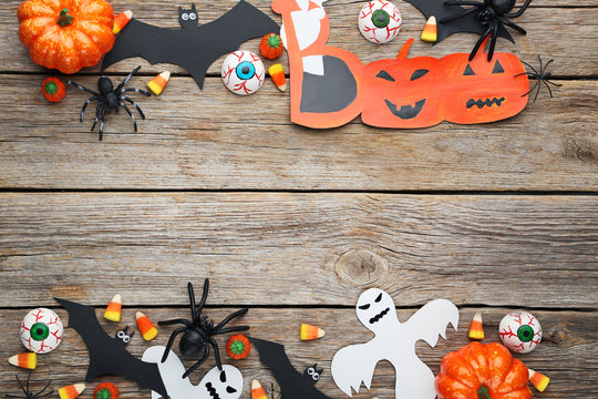 Halloween candy corns with ghosts, bats and spiders on wooden table