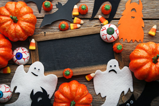 Halloween candy corns with wooden frame on grey table