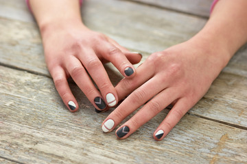 Woman hands with trendy manicure. Female hands with casual manicure on old wooden background. Nail design and spa.