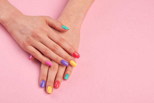 Female Hands With Stylish Colorful Nails. Beautiful Woman Hands With Pastel Colors Nails On Pink Background, Copy Space.