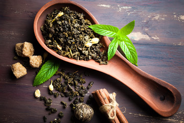 Dry tea leaves in a spoon on an old background