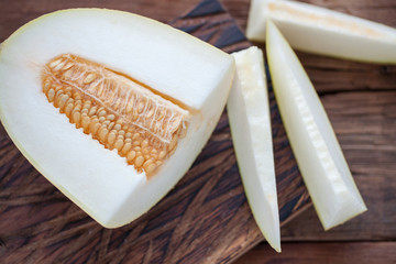 Fresh pieces of melon on the wooden background. top view