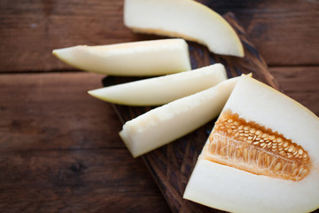 Fresh pieces of melon on the wooden background. top view