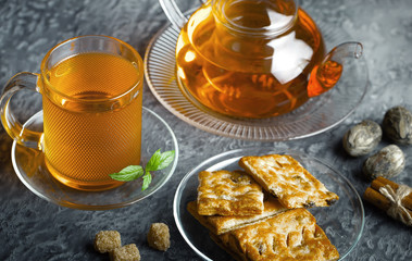 Tea in a cup on a metallic background in a composition with a cookware