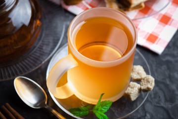 Tea in a cup on a metallic background in a composition with a cookware