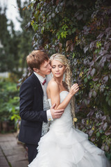 Wedding autumn. Bride and groom kissing in autumn park, couple in love	