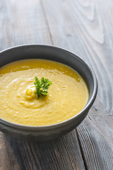 Bowl of pumpkin cream soup on the wooden table