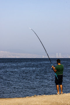 Man is fishing at seaside