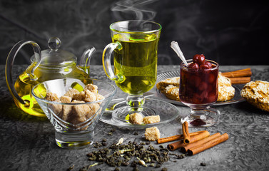Tea in a cup on a metallic background in a composition with a cookware