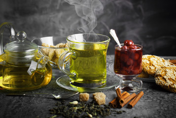 Tea in a cup on a metallic background in a composition with a cookware