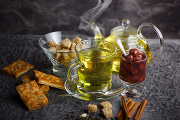 Tea in a cup on a metallic background in a composition with a cookware