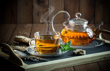 Tea in a cup on a metallic background in a composition with a cookware