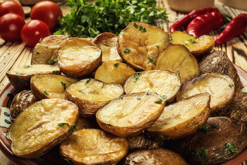 Close up of steaming hot baked potato,Hot buttered jacket baked potatoes,Roasted potato in bowl on wooden table,Oven-baked potatoes with sea salt and rosemary,toasted baked potato strewed with herbs.