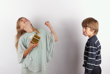 Happy girl with gift and an angry boy streching out her tongue