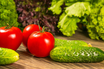 Fresh vegetables. Tomatoes and cucumbers on a wooden table. Delicious vegetarian food.