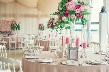 a reflective table at a wedding banquet, a table with candles, flowers and a beautiful tableware