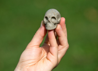 Sarsen stone skull from Avebury sacred site in young woman's hand
