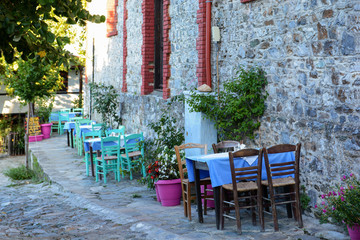 Plakat Traditional tavern from Greece with tables and chairs on open air