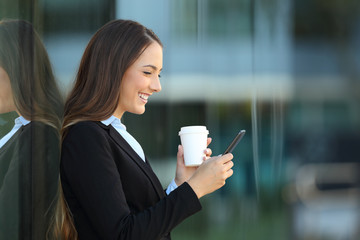 Profile of an executive using a smart phone on the street